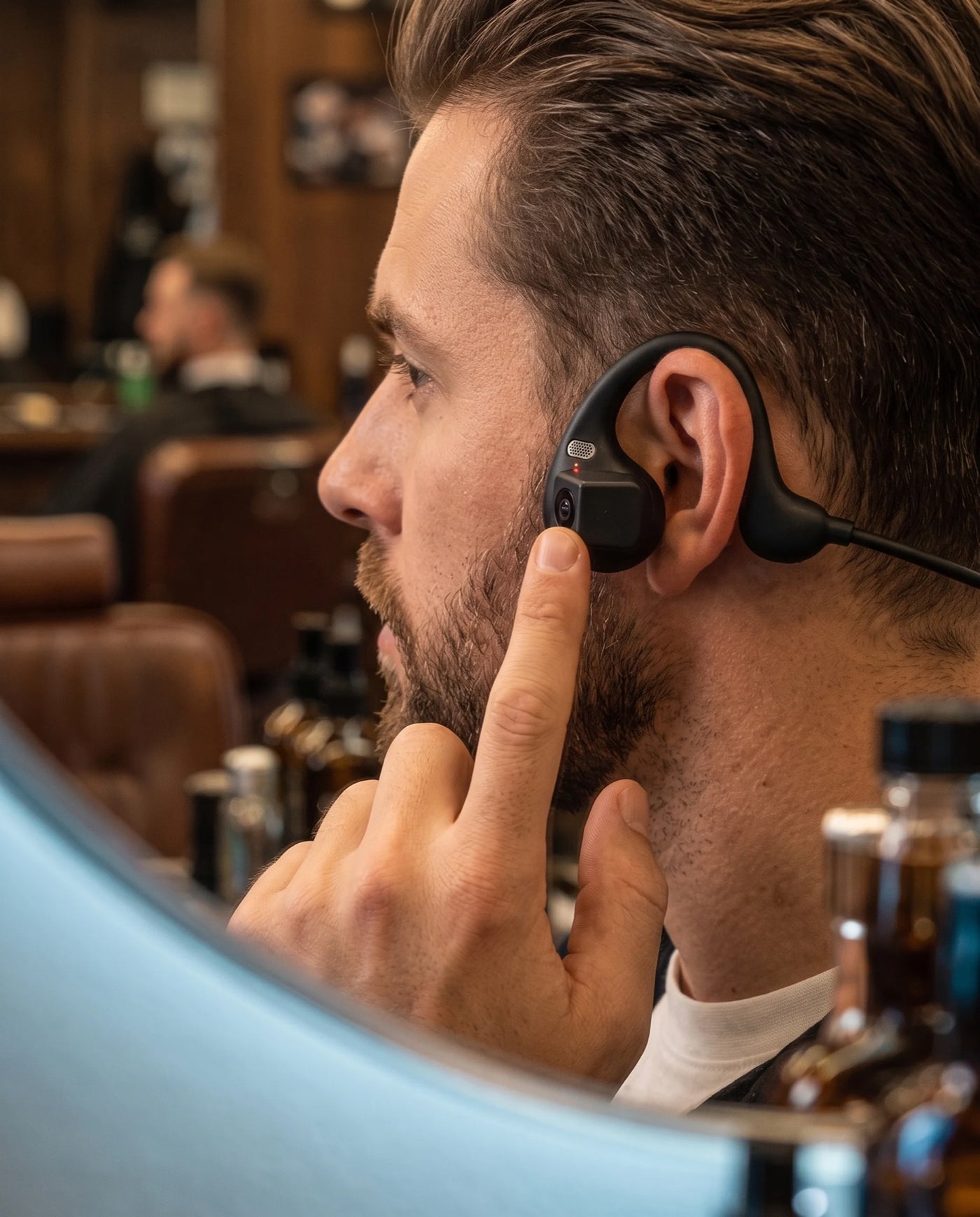 Finger tapping the record button on the ear piece